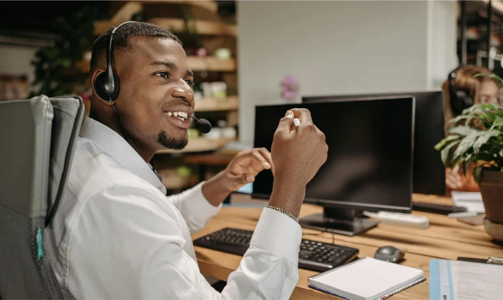 Answering Service Employee Wearing Headset Sitting At Computer